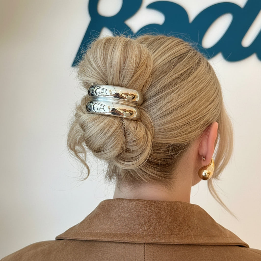 Close-up of a person's hair with decorative hair clips and earrings.